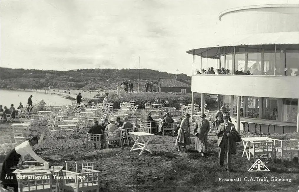 Svartvitt historiskt foto av Åsa Badrestaurant med uteservering vid havet.